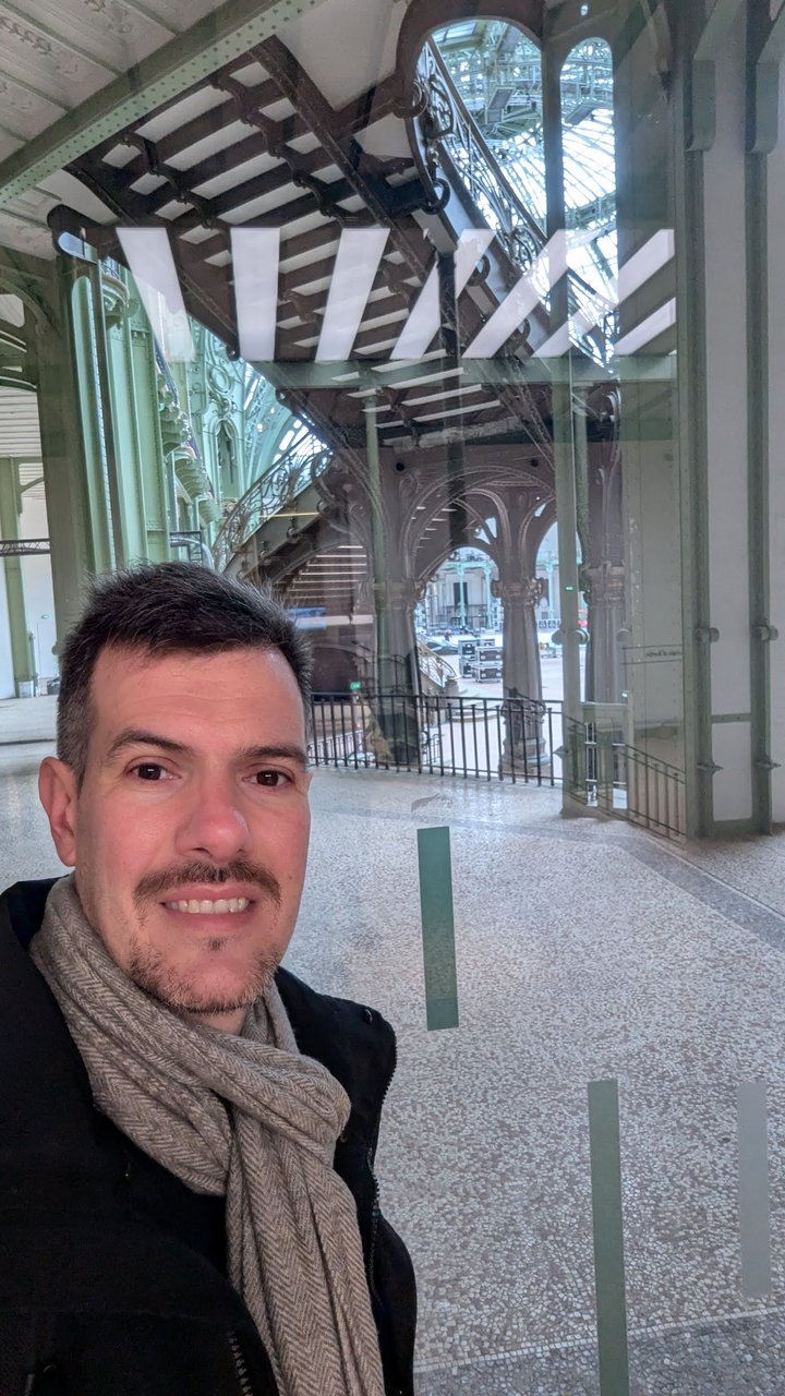 Luca Berton in front of Belle Ăpoque iron and glass architecture in Paris