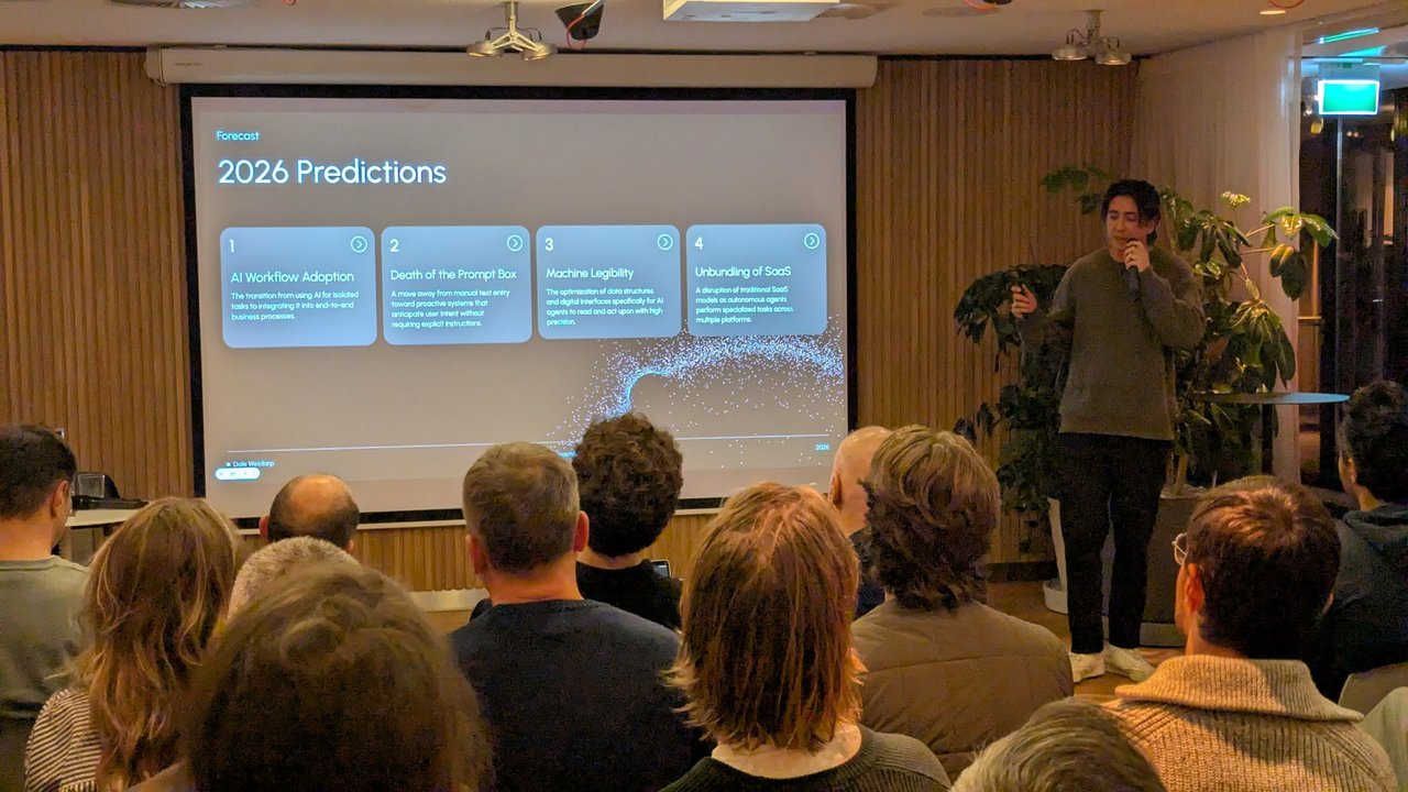 Dale Wesdorp presenting the 2026 Predictions slide: AI Workflow Adoption, Death of the Prompt Box, Machine Legibility and Unbundling of SaaS