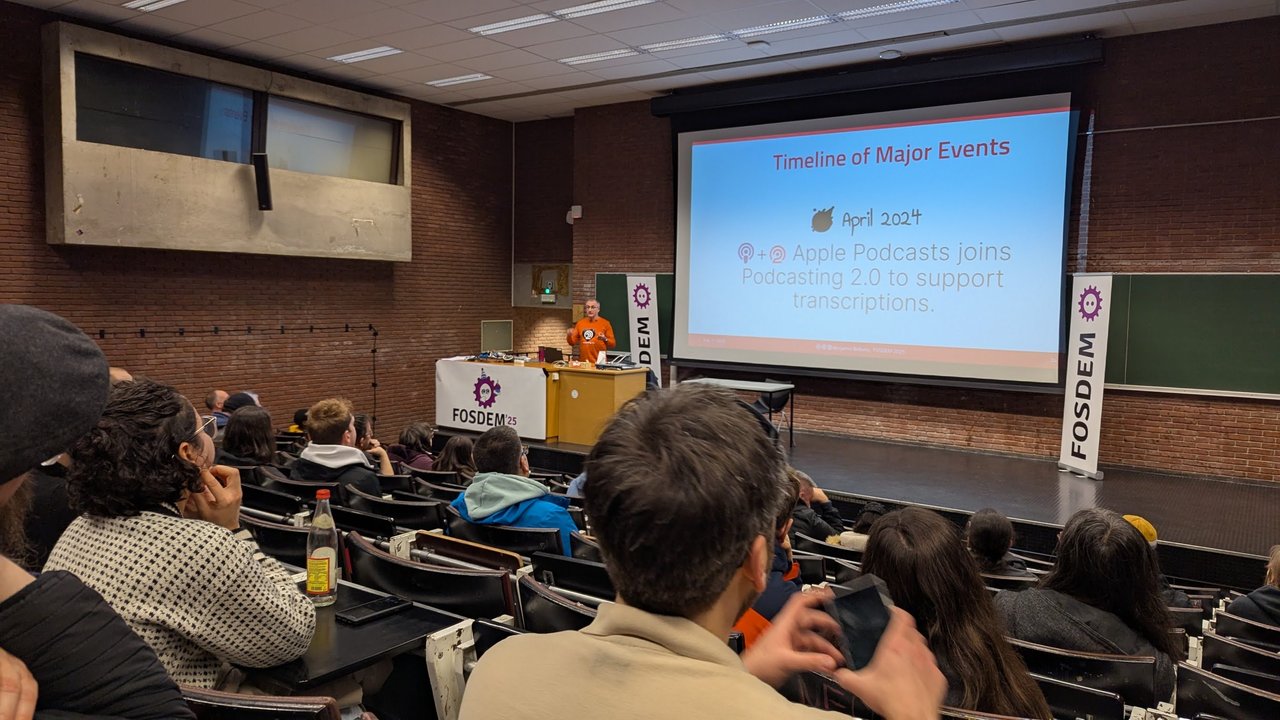 Benjamin Bellamy presenting a Timeline of Major Events slide at FOSDEM 2025: in April 2024 Apple Podcasts joined Podcasting 2.0 to support transcriptions