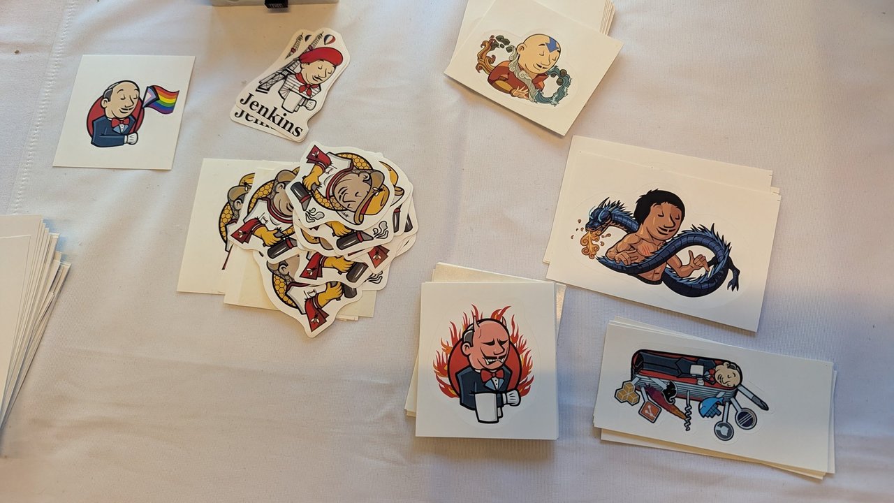 Jenkins stickers spread out on a stand table at FOSDEM 2025