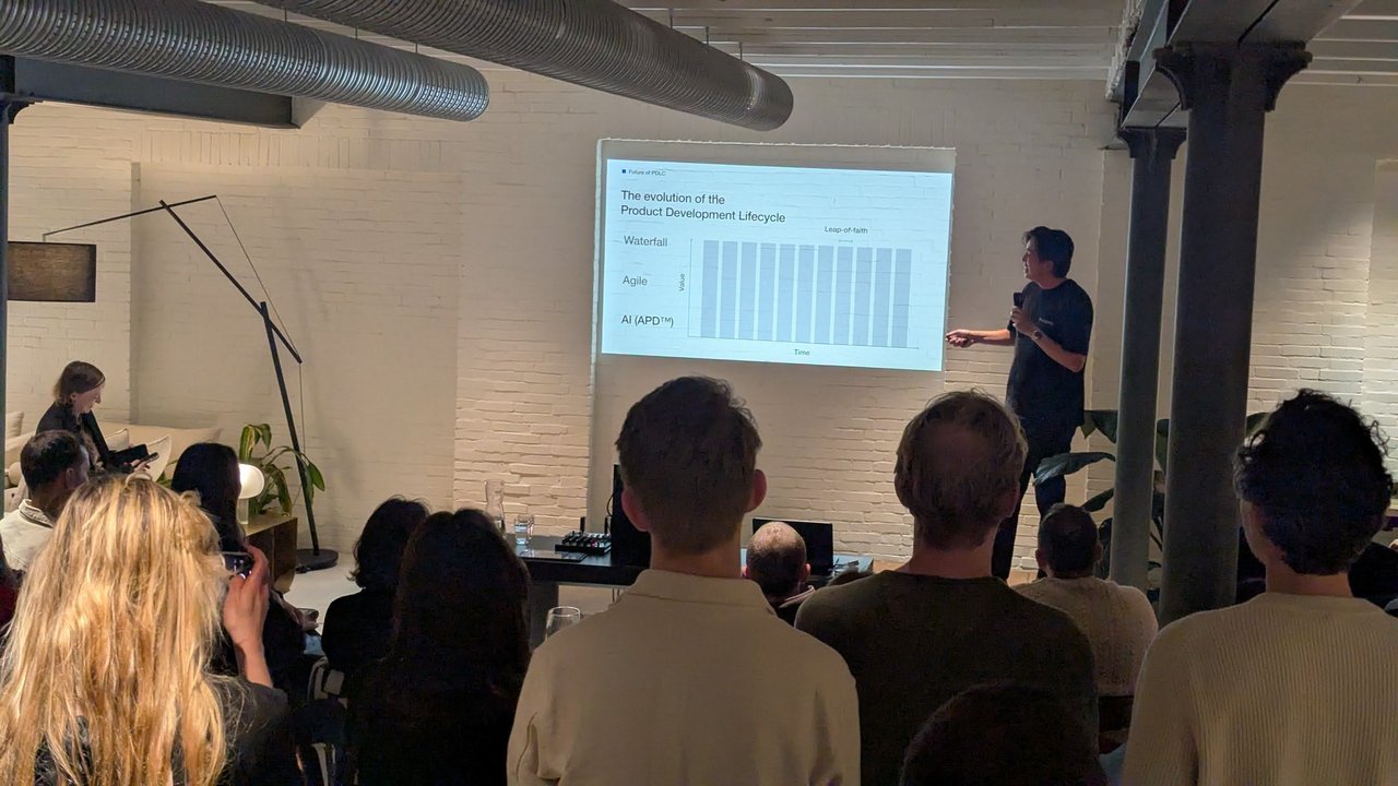 miyagami speaker presenting The evolution of the Product Development Lifecycle slide with Waterfall, Agile and AI (APD) rows
