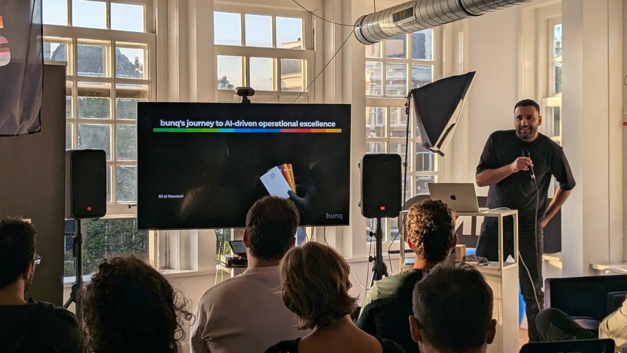 Ali el Hassouni presenting the title slide bunq's journey to AI-driven operational excellence at the ML6 office