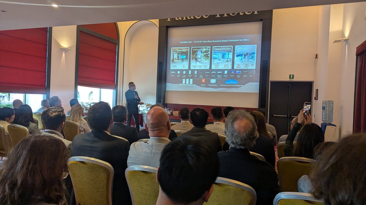 The HUAWEI eKit 4+10+N One-Stop Scenario-Based Solutions for SMEs slide, with the presenter beside the screen