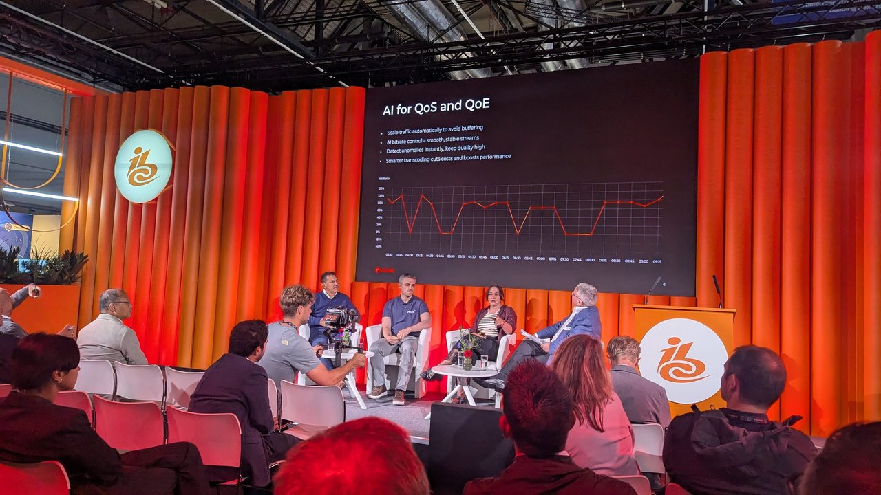 The AI for QoS and QoE slide above four panellists on a stage at IBC 2025, with a hit-ratio chart dropping to zero several times between 03:30 and 09:15