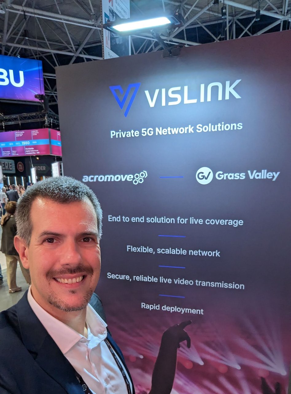 Luca Berton in front of the Vislink stand at IBC 2025 advertising Private 5G Network Solutions with acromove and Grass Valley