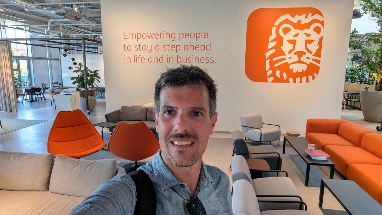 Luca Berton taking a selfie in front of the ING lion logo in the building lobby in Amsterdam