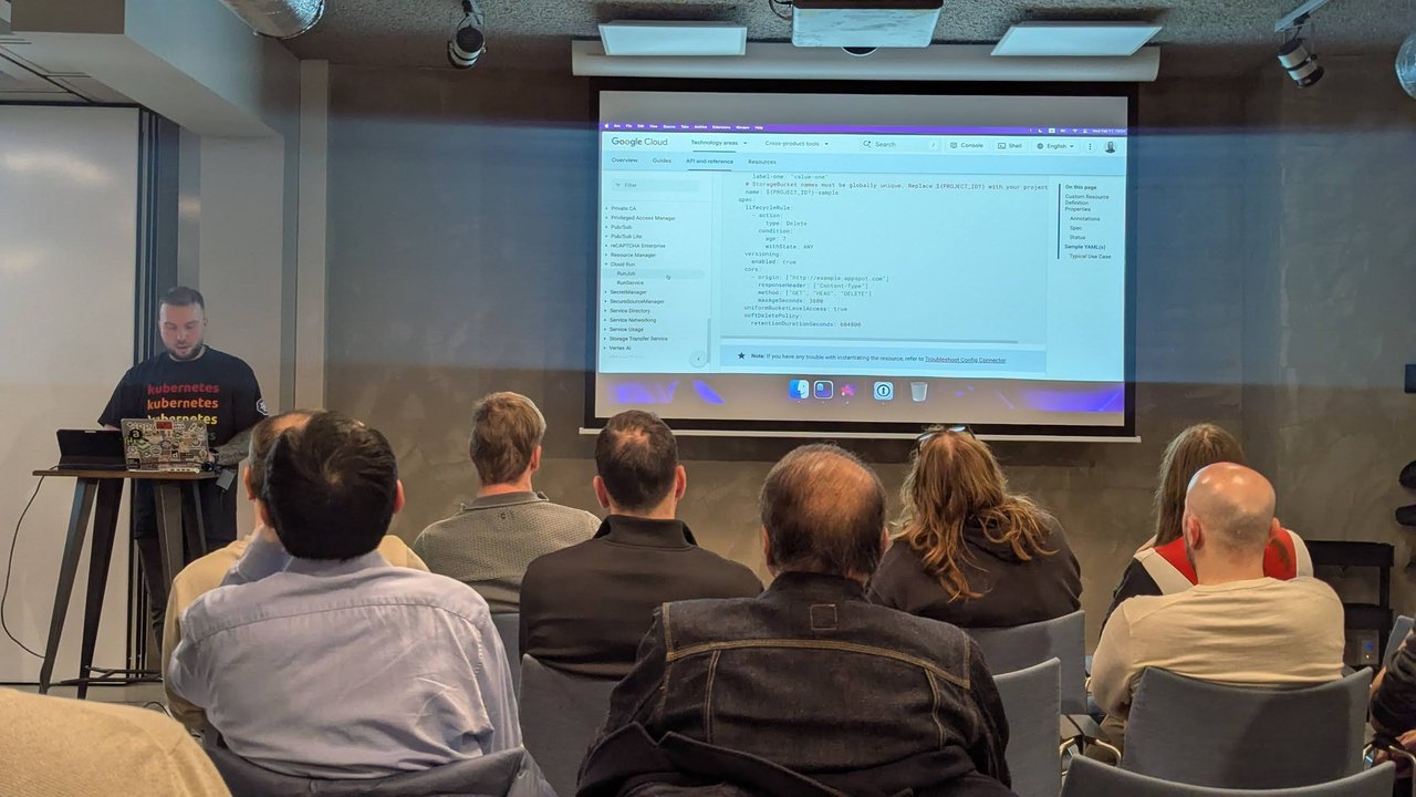 The Google Cloud Config Connector reference page on screen at the Xebia meetup in Amsterdam, showing a sample StorageBucket manifest with lifecycleRule, versioning, cors, uniformBucketLevelAccess and softDeletePolicy