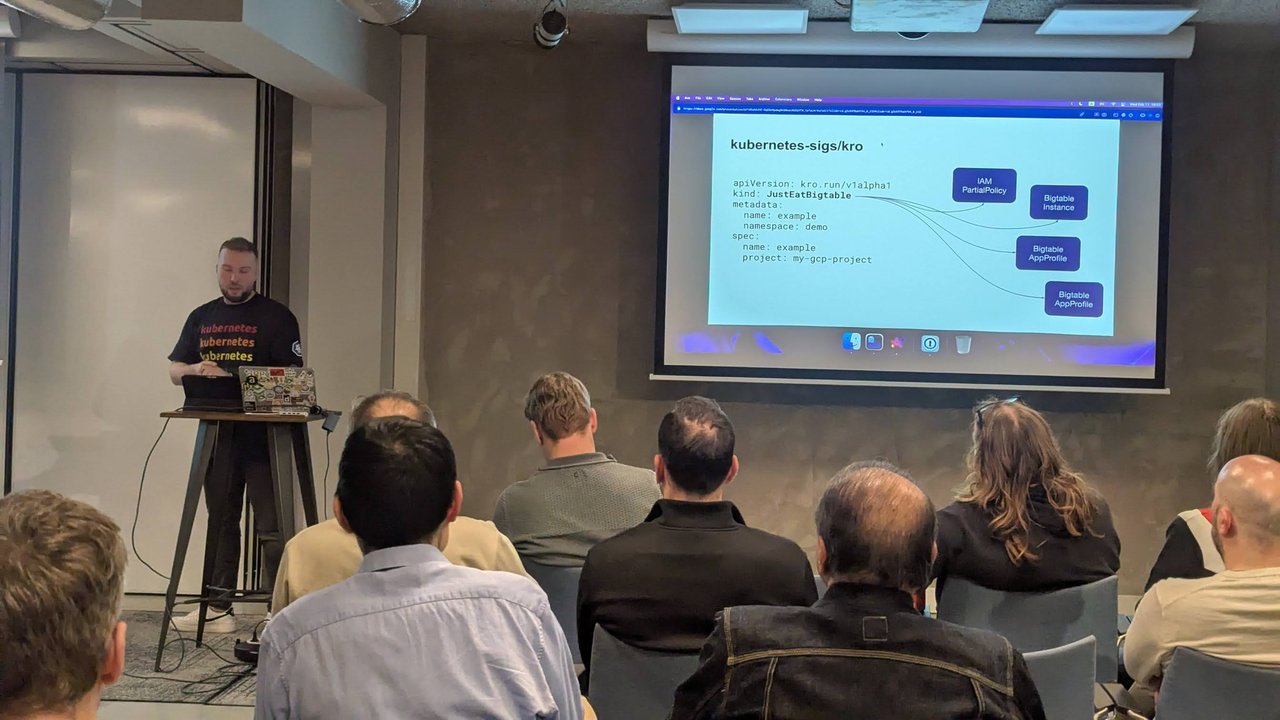 Close-up of the kubernetes-sigs/kro slide at the Xebia meetup in Amsterdam: a JustEatBigtable instance with apiVersion kro.run/v1alpha1, a name and a project, with arrows to an IAM PartialPolicy, a Bigtable Instance and two Bigtable AppProfiles