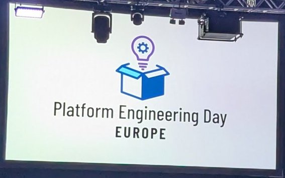 Platform Engineering Day Europe logo on the screen in the hall at ExCeL London before a session