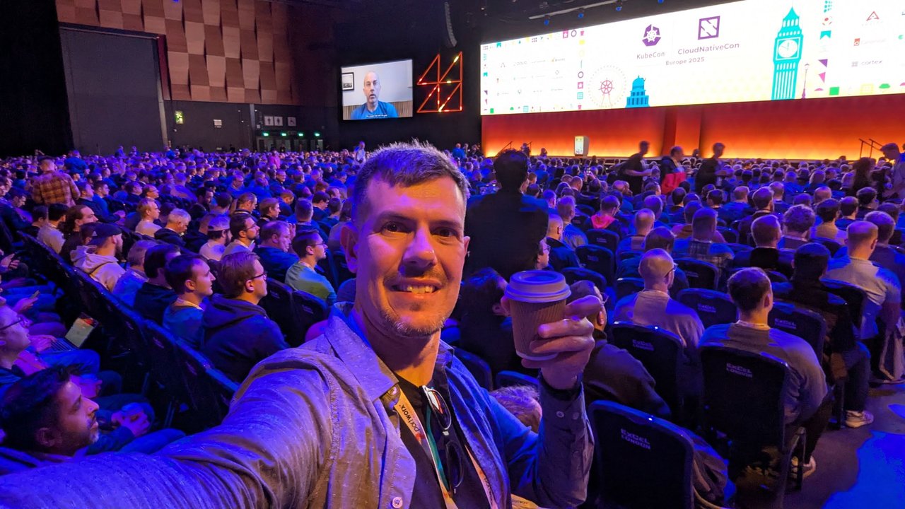 Luca Berton with a coffee taking a selfie in the packed keynote hall at ExCeL London before the Wednesday keynote