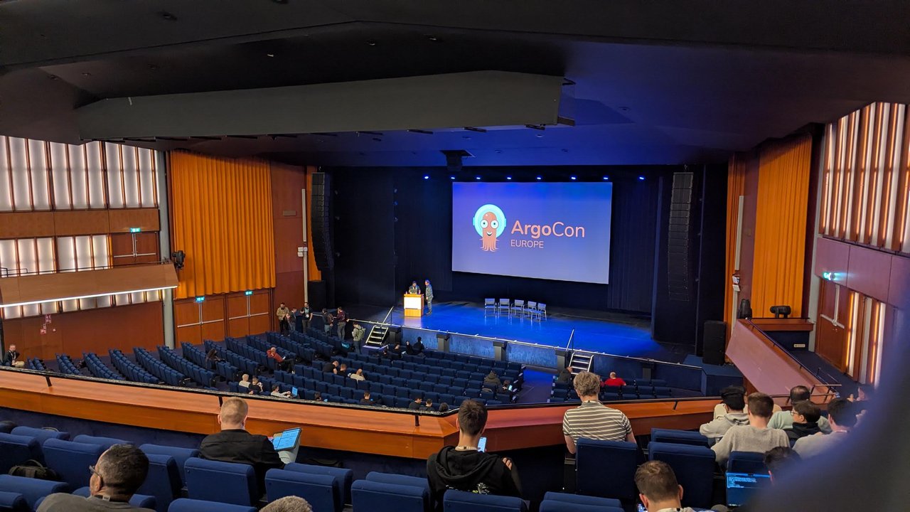 The ArgoCon Europe 2026 auditorium at RAI Amsterdam, with the ArgoCon logo on the screen and the audience taking their seats