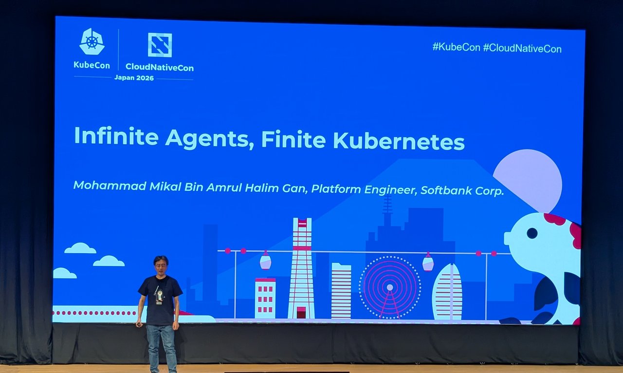 The SoftBank keynote title slide Infinite Agents, Finite Kubernetes on the KubeCon Japan 2026 main stage, with the speaker in front of the screen