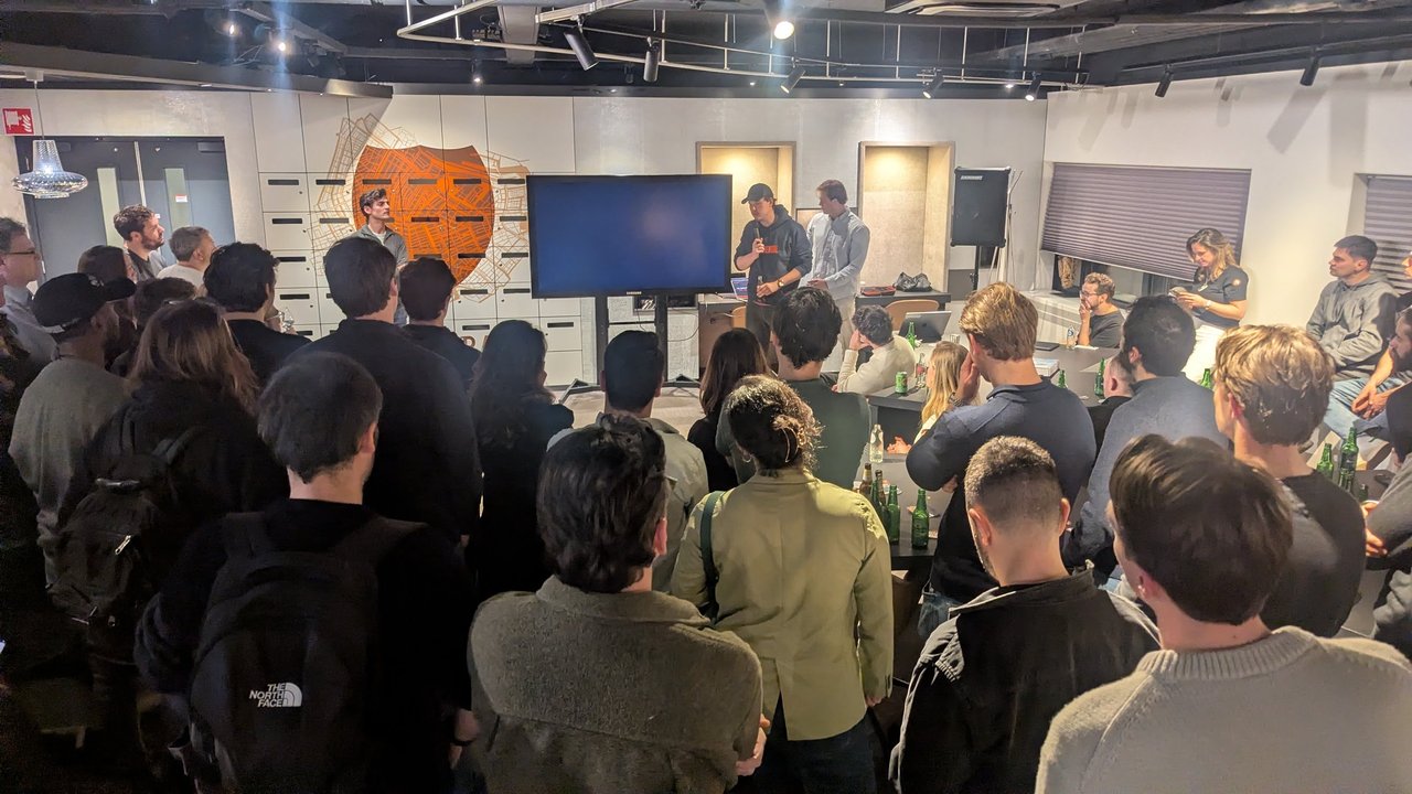 The audience at the AI Foundry office during the Q&A after the robotics talk, with the speakers standing next to the screen