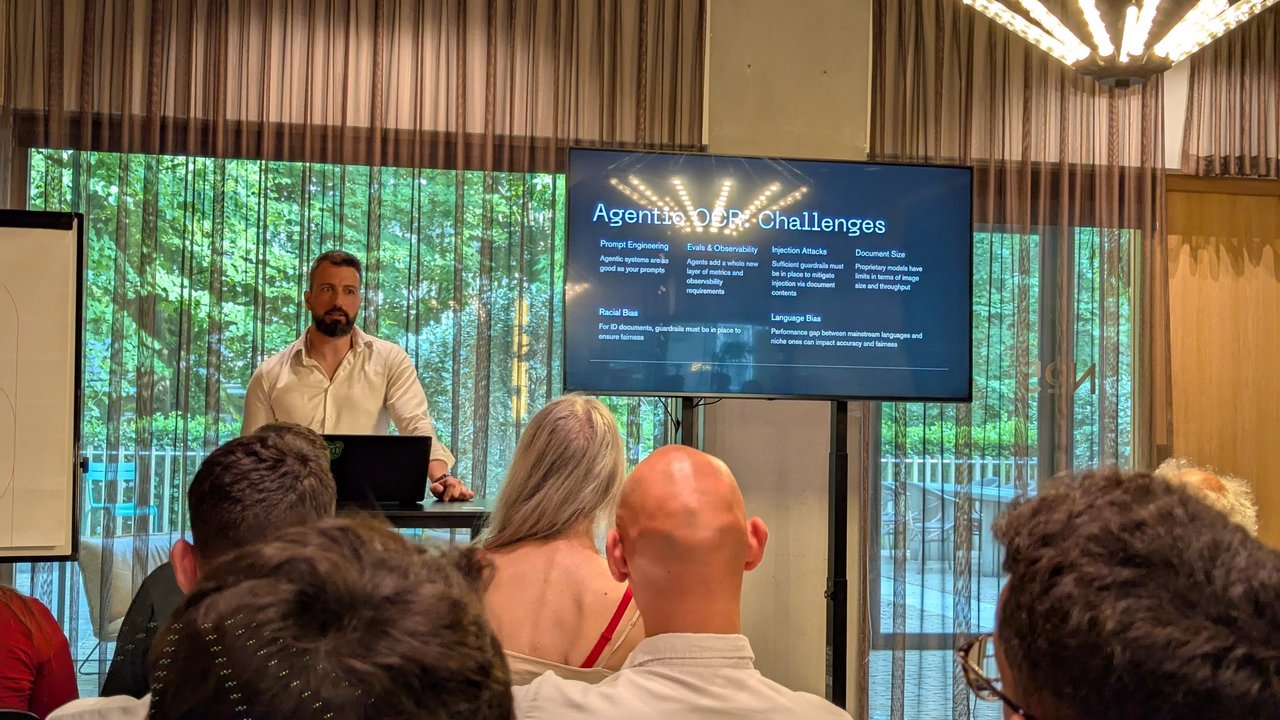 Speaker next to a slide titled Agentic OCR: Challenges listing prompt engineering, evals, injection attacks, document size, racial bias and language bias