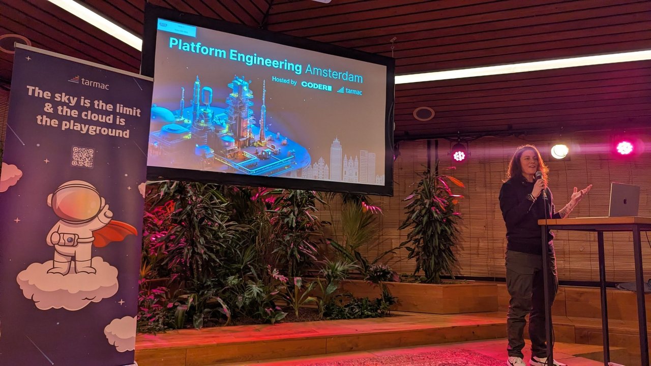 The Platform Engineering Amsterdam opening slide, "Hosted by Coder and tarmac", on the screen at Tolhuistuin next to a tarmac roll-up banner