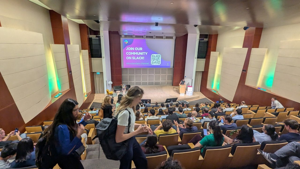The auditorium at the MLOps Community AI Agent World Tour in Amsterdam, with the audience seated and a Join our community on Slack slide on the screen