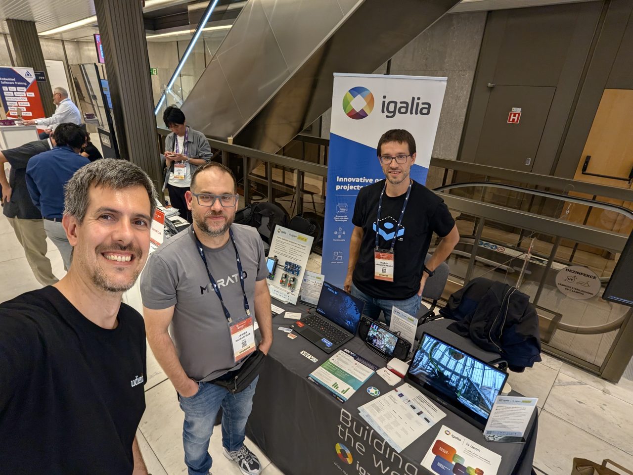 Luca Berton at the Igalia booth with members of the Igalia team