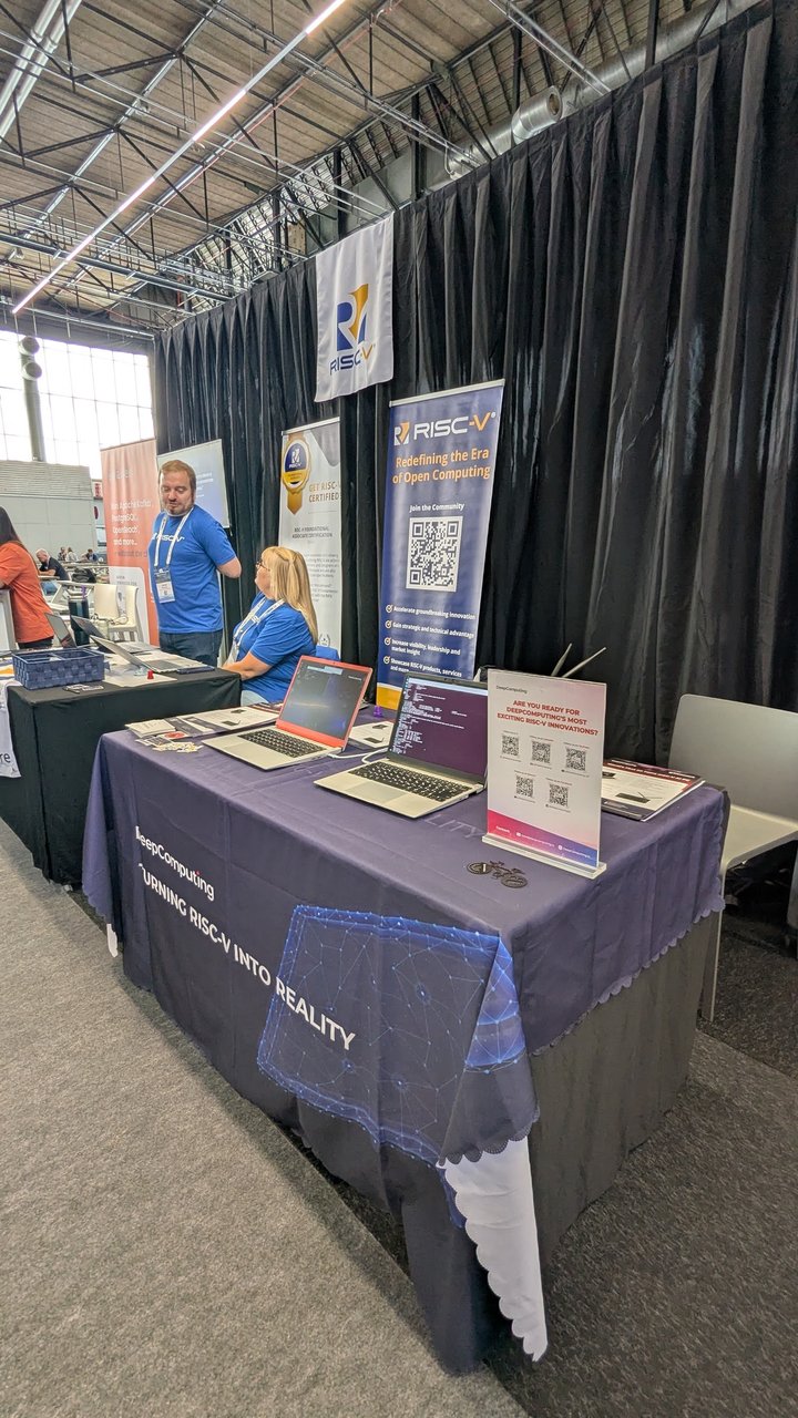 DeepComputing table at the RISC-V booth at Open Source Summit Europe 2025, with RISC-V laptops running Linux under the Turning RISC-V into Reality banner