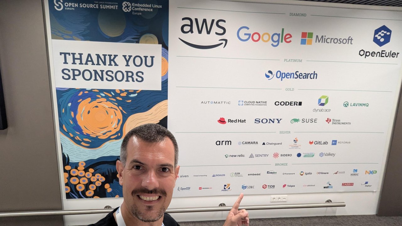 Luca Berton pointing at the Open Source Summit Europe and Embedded Linux Conference 2025 sponsor wall, with AWS, Google, Microsoft and openEuler as Diamond sponsors