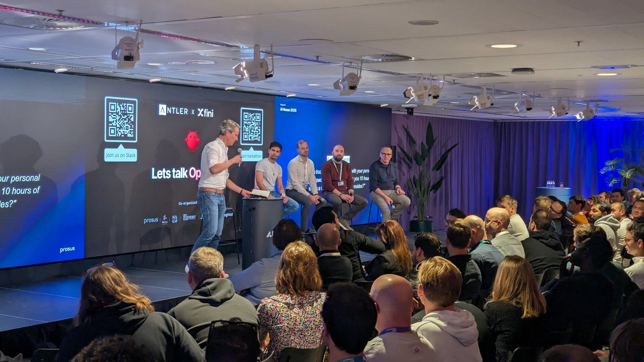 Moderator and panel on stage at the OpenClaw Builders Community meetup at AI House Amsterdam, under the Lets talk OpenClaw screens