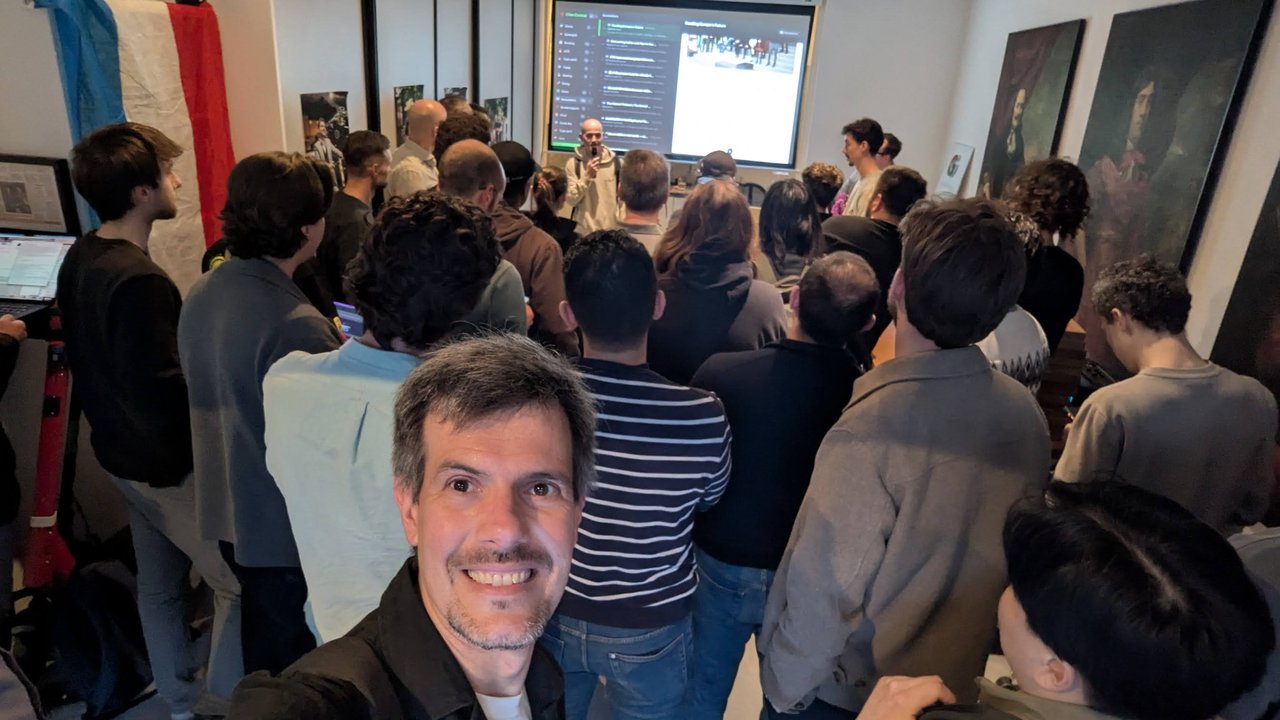 Luca Berton taking a selfie in a packed room at the OpenClaw Demo + Hackathon Amsterdam, with builders standing in front of the projector