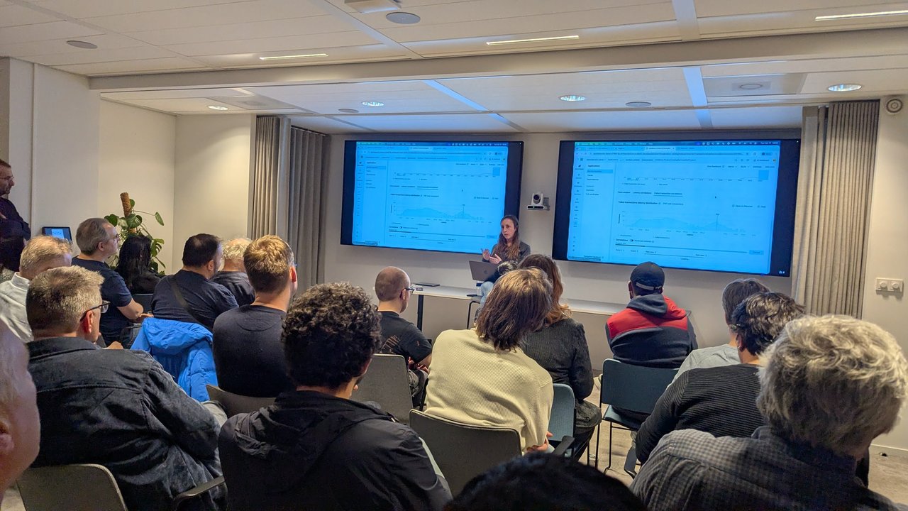 The room at the SRE NL meetup at Elastic Amsterdam during the live Elastic Observability demo, with failed transaction latency and correlations on both screens