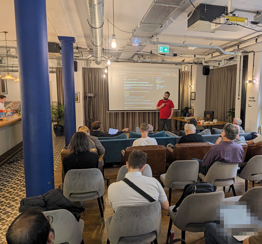 Wide view of the OTel meetup room at Mindspace Dam in Amsterdam, with the audience in armchairs and sofas facing the screen and the speaker presenting