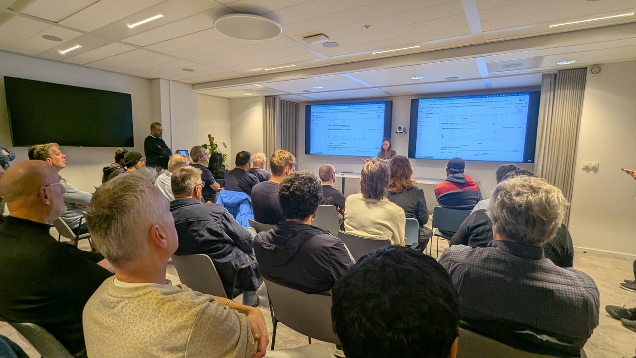 The room at the SRE NL meetup at Elastic Amsterdam during the OpenTelemetry talk, with the Elastic Observability live demo on both screens