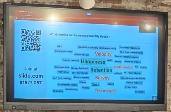 Slido word cloud on screen at Picnic answering What metrics can be used to quantify DevEx, with Happiness, Retention, Velocity, Survey and Dora as the largest words