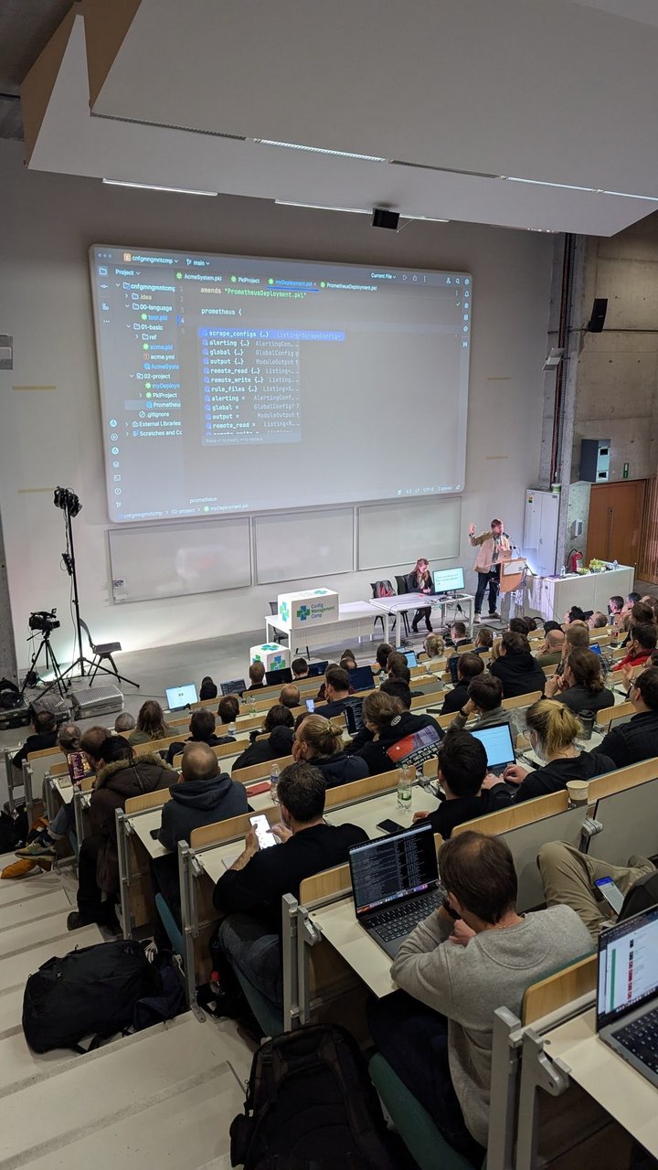 A CfgMgmtCamp 2025 demo in a JetBrains IDE: myDeployment.pkl amends PrometheusDeployment.pkl and code completion lists Prometheus fields such as scrape_configs, alerting, global and rule_files
