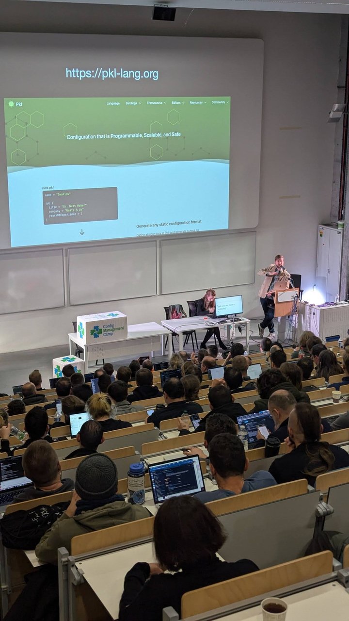 A CfgMgmtCamp 2025 slide showing the pkl-lang.org homepage: Configuration that is Programmable, Scalable, and Safe, a bird.pkl sample and the line Generate any static configuration format