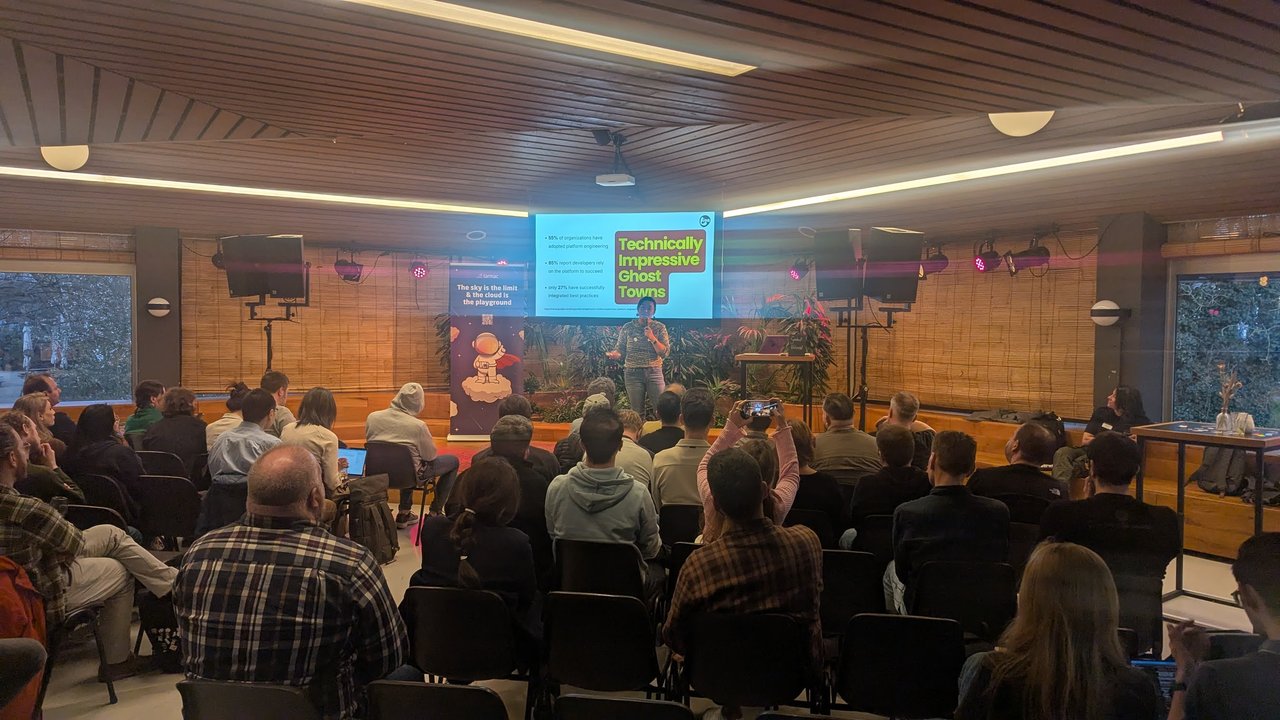 Lian presenting the Technically Impressive Ghost Towns slide: 55% adopted platform engineering, 85% rely on the platform, only 27% integrated best practices