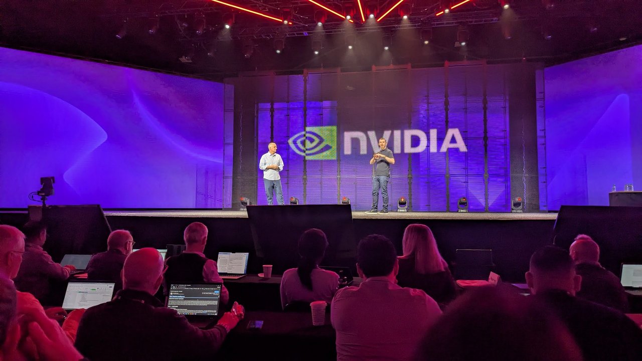 Two people on stage in front of an NVIDIA logo at the Red Hat Summit keynote