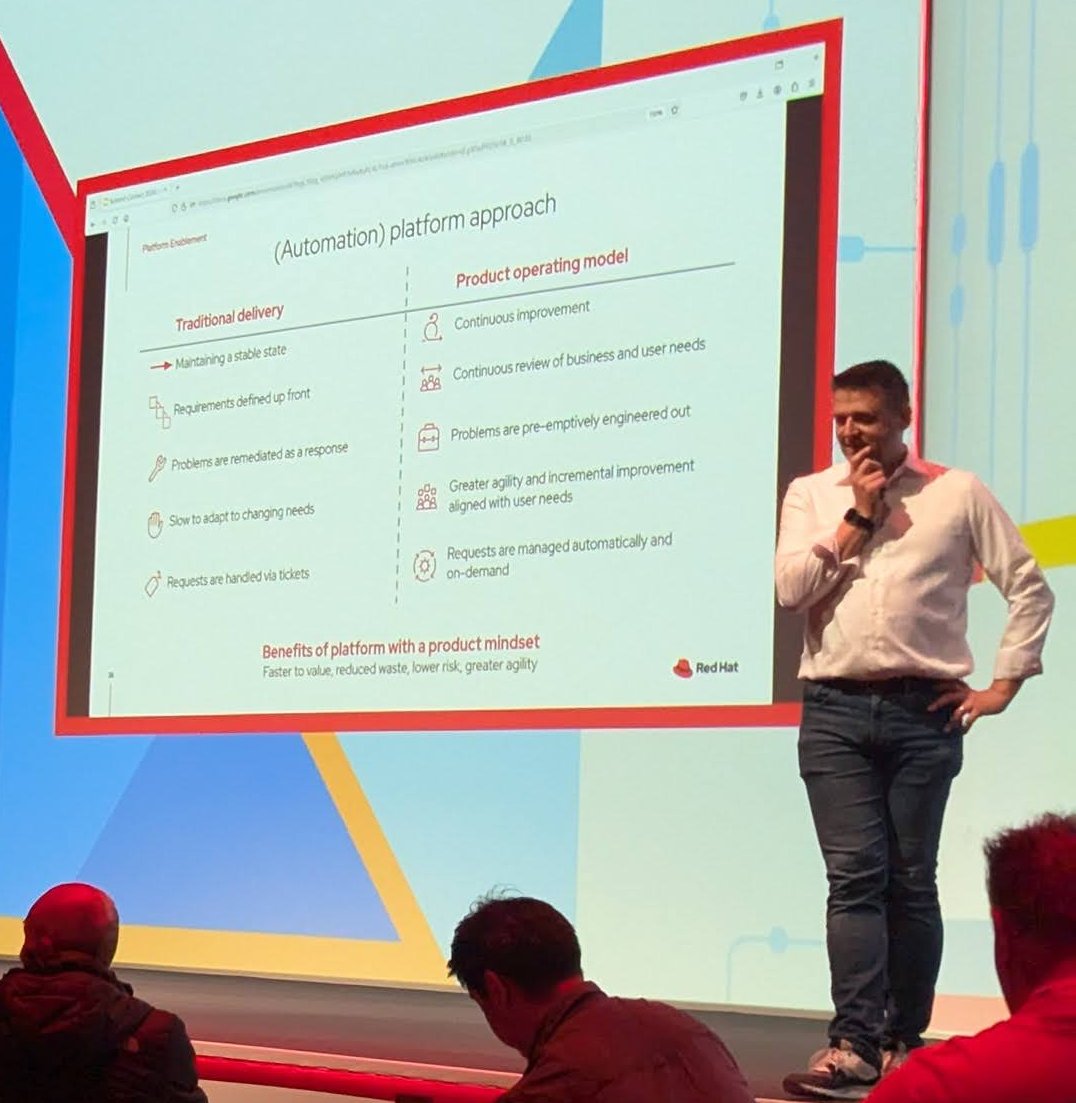 Slide titled (Automation) platform approach comparing traditional delivery with a product operating model, with a presenter on stage beside it
