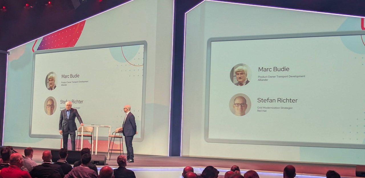 Marc Budie of Alliander and Stefan Richter of Red Hat on stage at Red Hat Summit Connect Utrecht 2025, under slides with their names and titles
