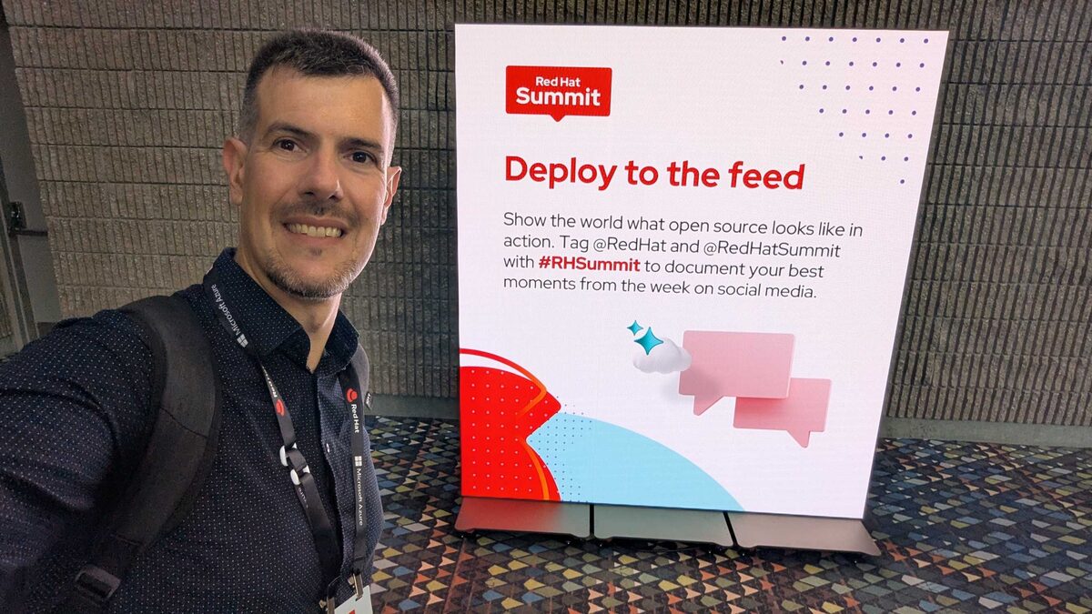 Luca Berton at Red Hat Summit 2026 — Deploy to the Feed social media sign