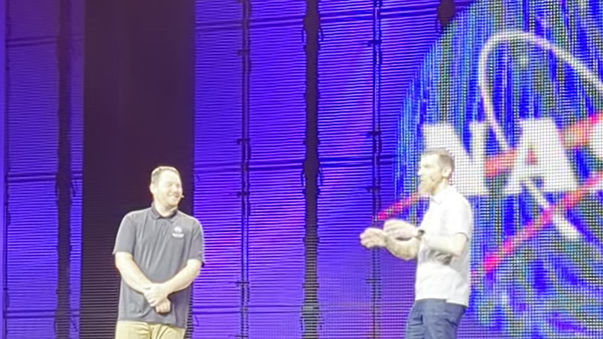 NASA presenters on the keynote stage at Red Hat Summit 2026, credited to Josiah Johnson, Operations Support Center Systems Architect at NASA Marshall Space Flight Center