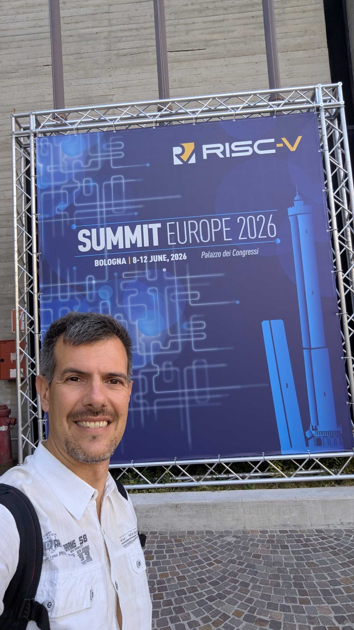 Luca Berton at RISC-V Summit Europe 2026 venue entrance, Palazzo dei Congressi Bologna