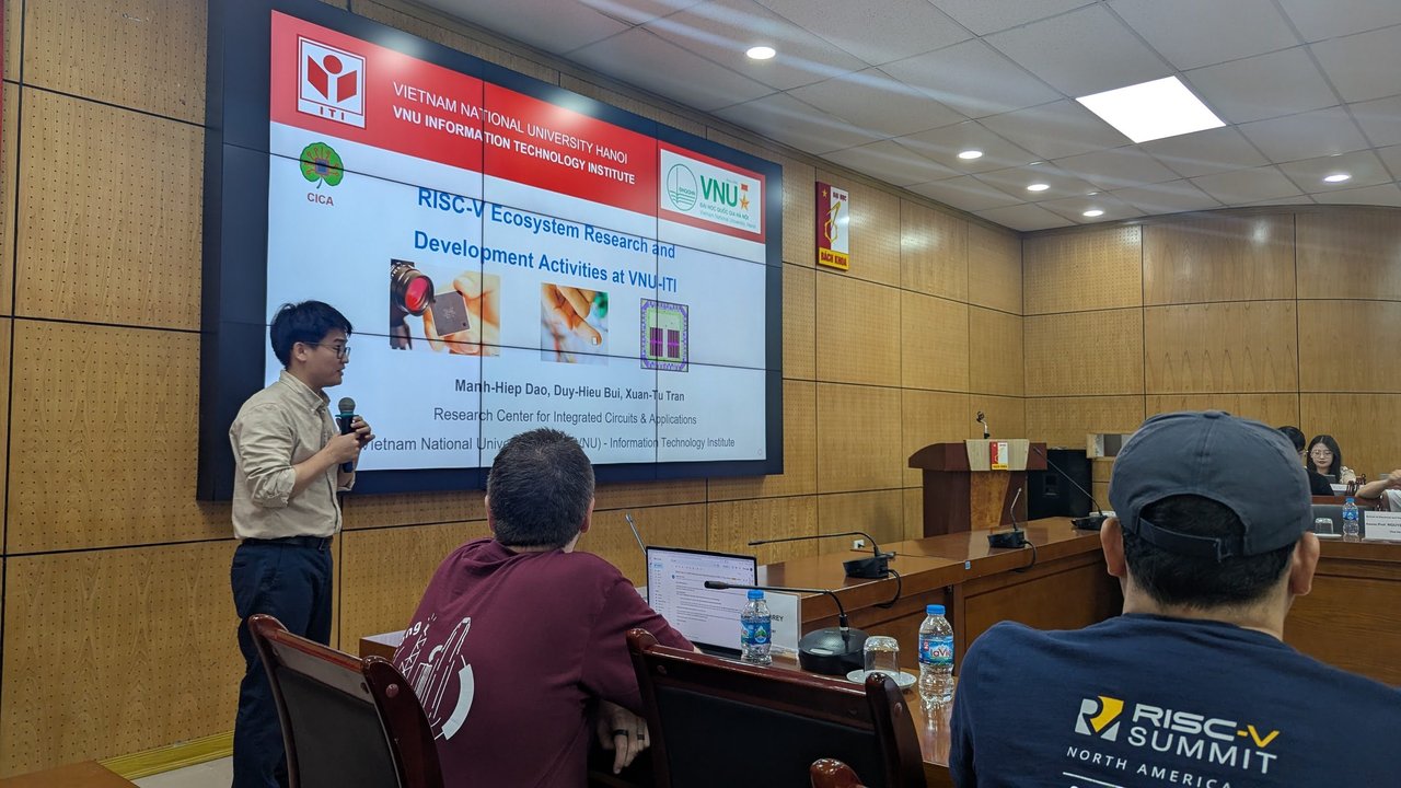 The VNU-ITI title slide with chip images, and the presenter at the front of the room