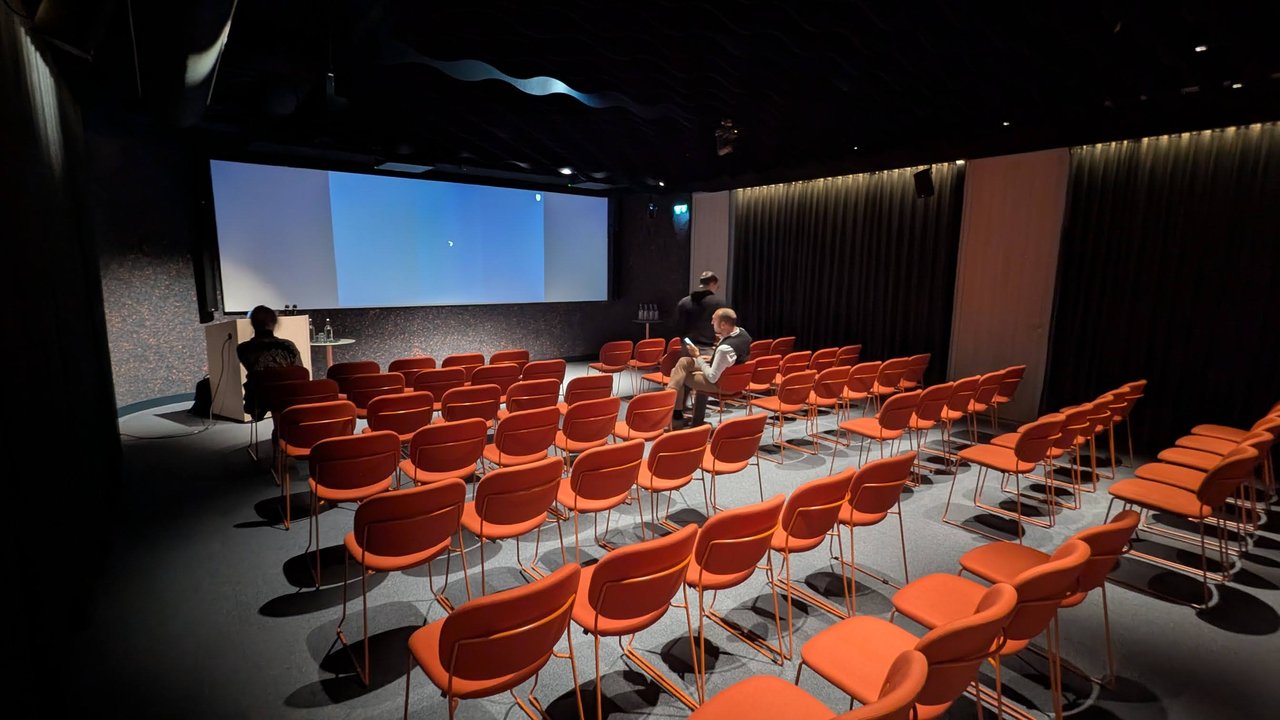 The JetBrains event room in Amsterdam with rows of orange chairs, mostly empty before the meetup