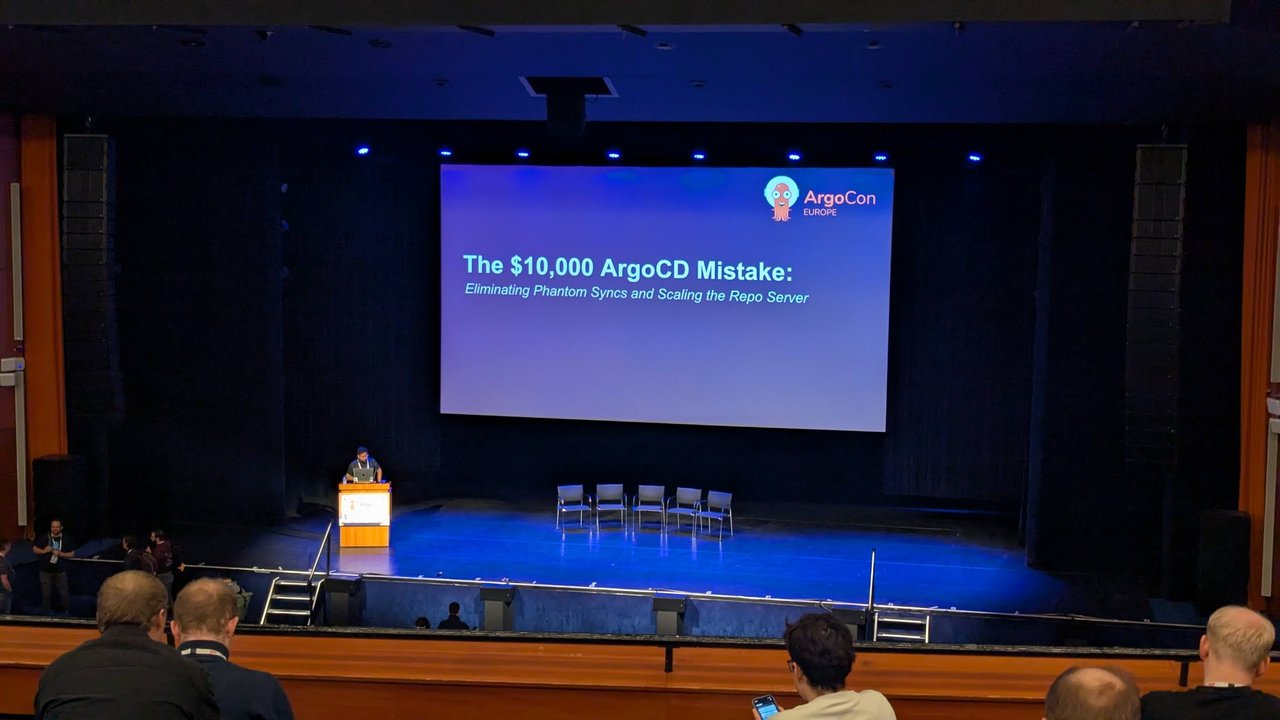 Title slide of The $10,000 ArgoCD Mistake: Eliminating Phantom Syncs and Scaling the Repo Server on the ArgoCon Europe stage at KubeCon Europe 2026 in Amsterdam