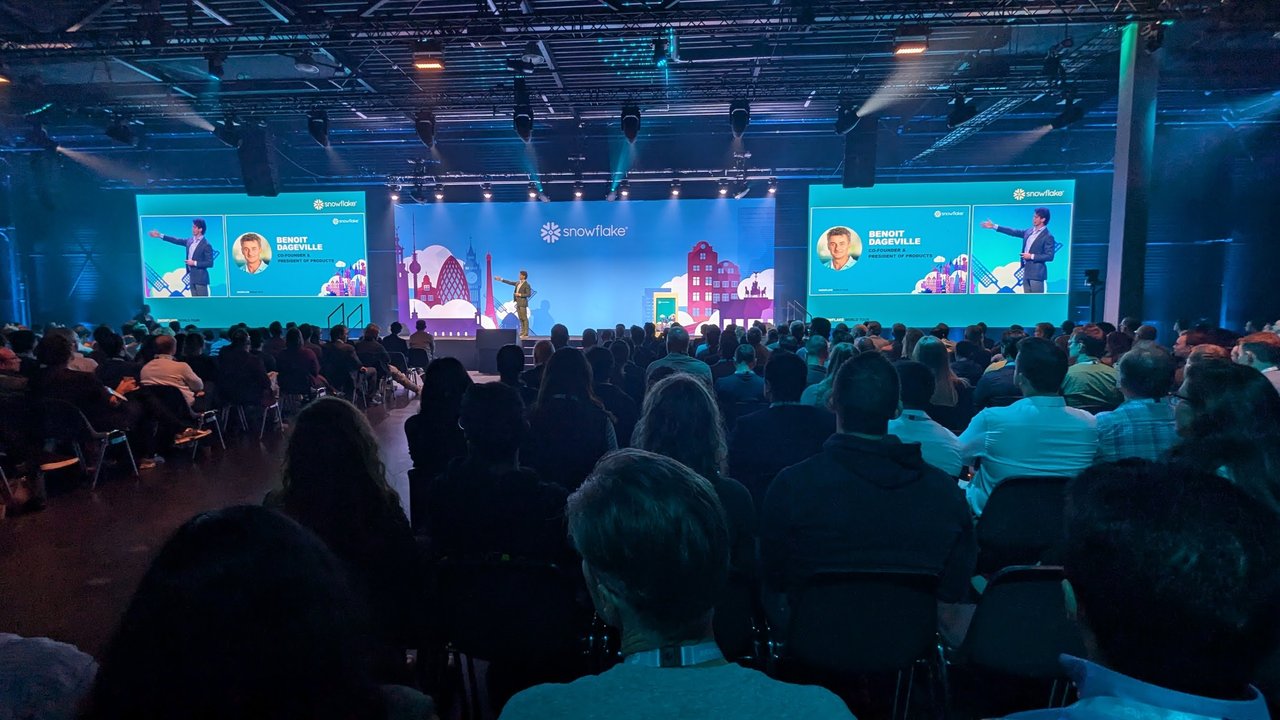 Keynote at Snowflake World Tour Amsterdam 2024 in a packed hall, with Benoit Dageville's name and photo on both side screens