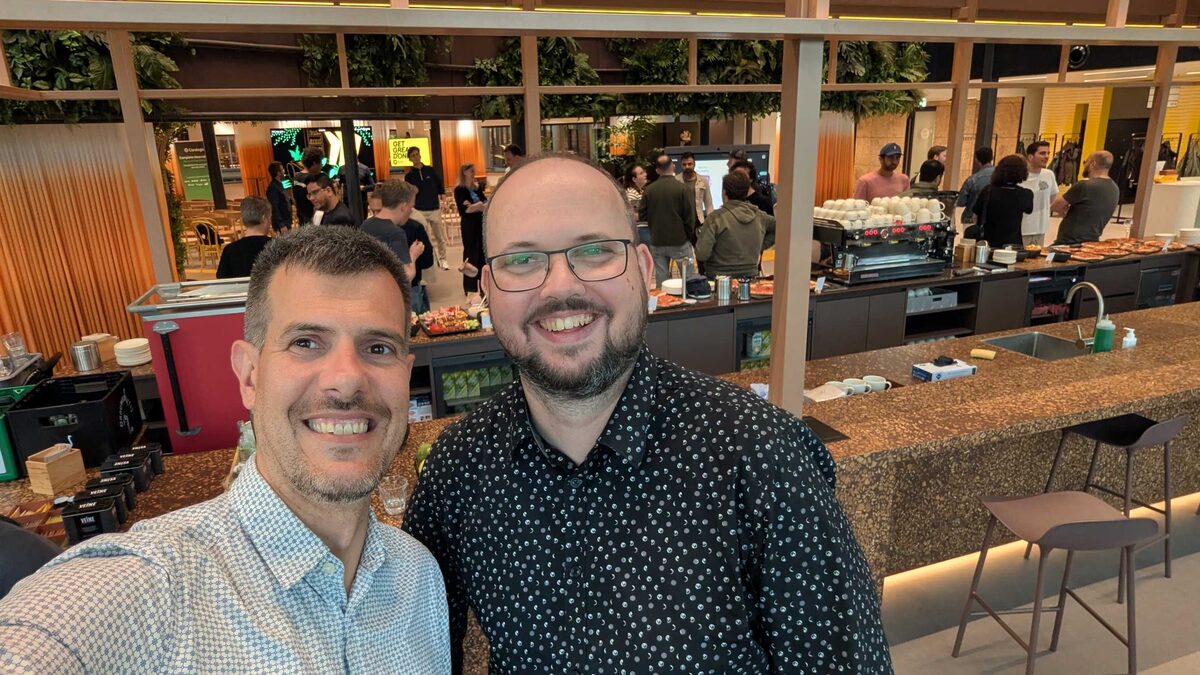 Luca Berton with Wilco Burggraaf at the Miro Amsterdam office during the SRE NL meetup — coffee bar and catering area in background