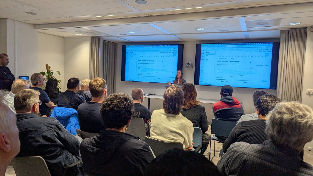 Evelien Schellekens presenting a live Elastic APM demo at the SRE NL meetup, showing a failed transaction latency distribution for a service