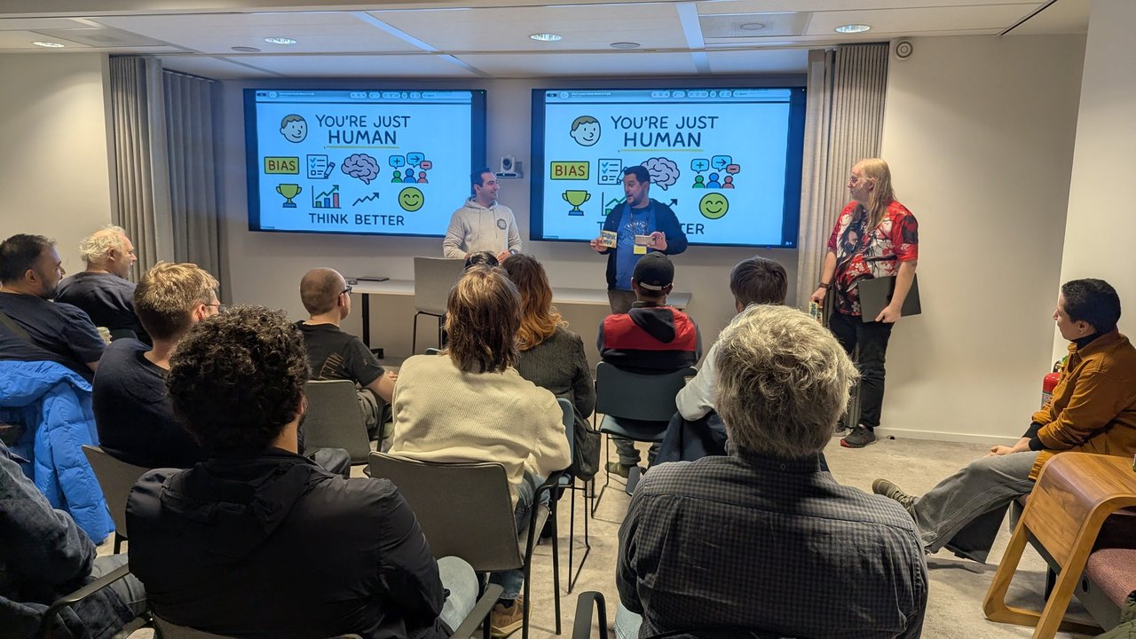Organisers and the speaker at the front of the room at the SRE NL meetup at Elastic Amsterdam in front of the You're just human, think better closing slide