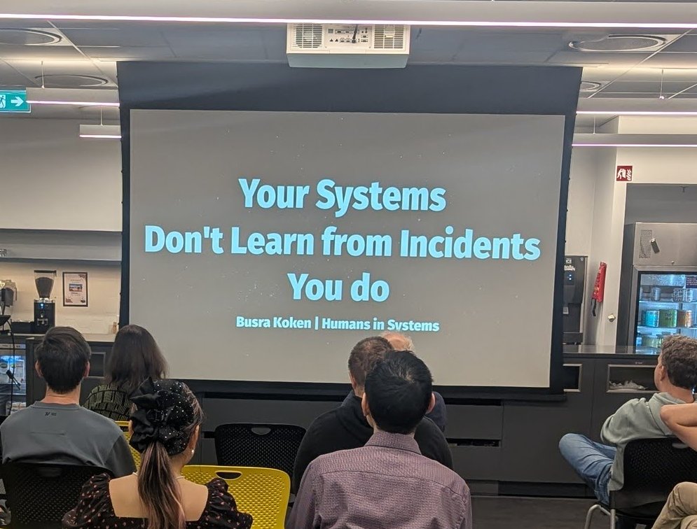 Busra Koken's title slide, Your Systems Don't Learn from Incidents, You do, with Humans in Systems underneath