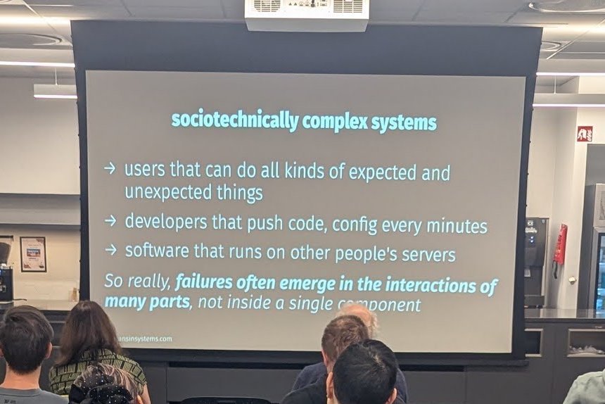 The sociotechnically complex systems slide: users, developers pushing code and config every few minutes, software on other people's servers, failures emerging in the interactions of many parts