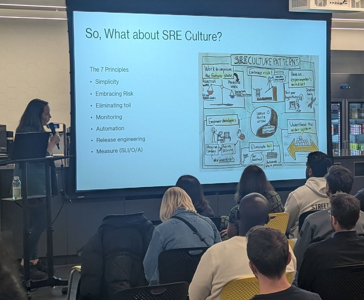 Andrea presenting the So, What about SRE Culture slide with the seven SRE principles and a hand-drawn SRE culture patterns sketch