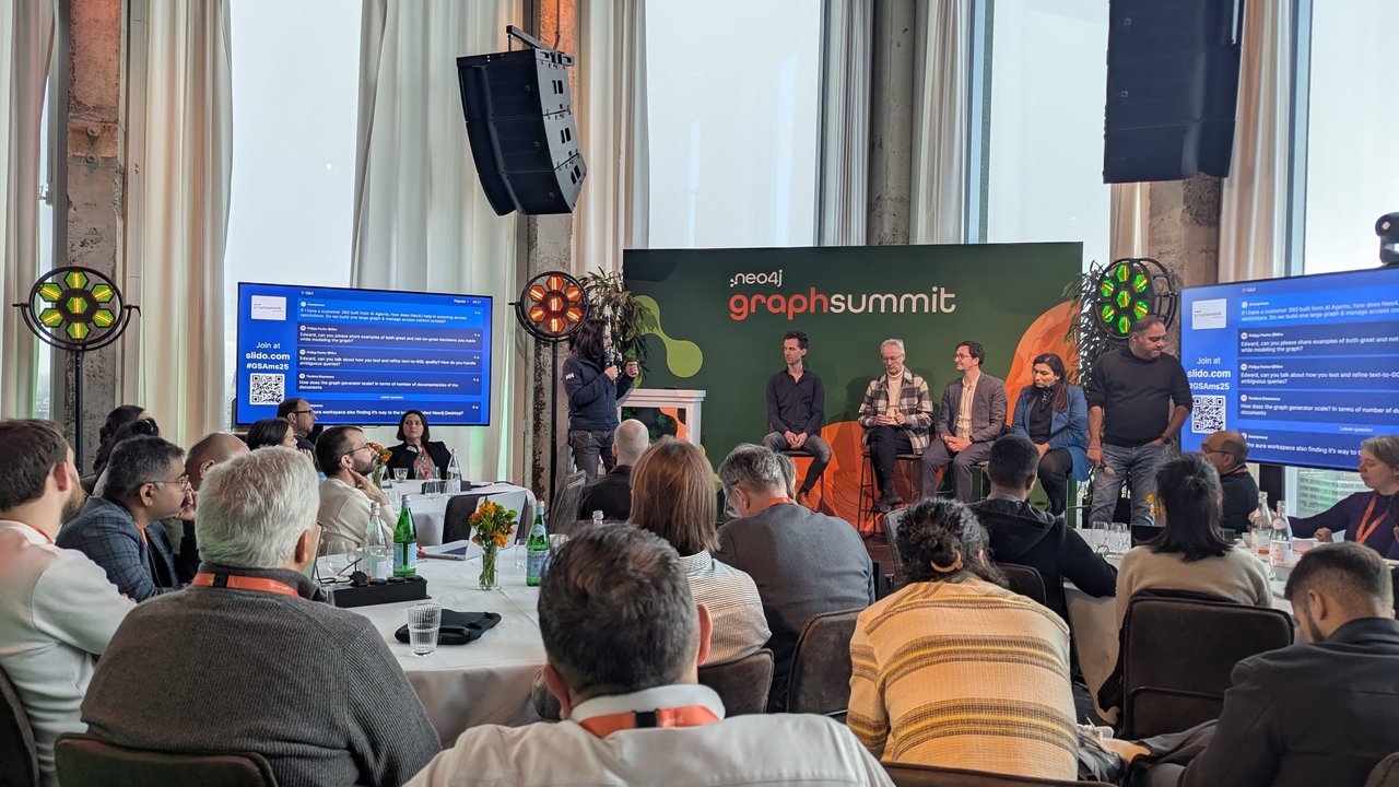 Stephen Chin moderating the GraphSummit Amsterdam 2025 Q&A panel, with Slido questions on the screens either side of the stage