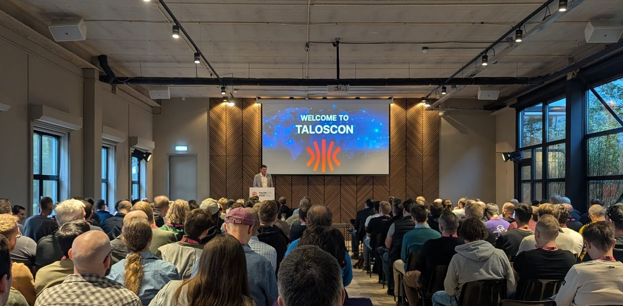 TalosCon 2025 opening keynote at Venue Collective, a full room facing a Welcome to TalosCon slide